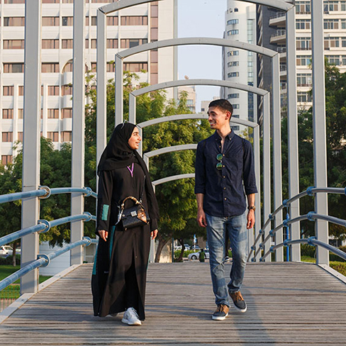 Two students walking on a bridge. Links to Beneficiary Designations designations.jpg