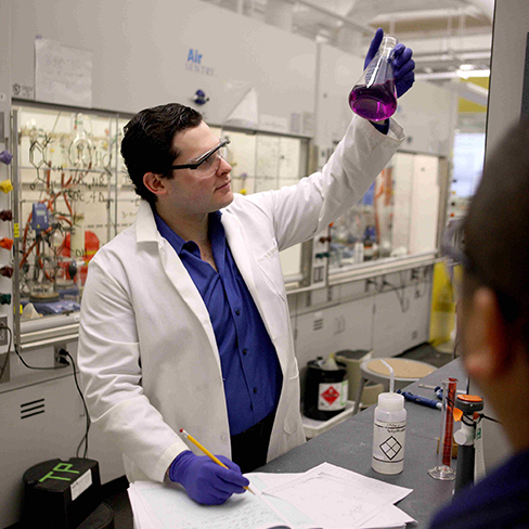 A student holding up a beaker. Links to What to Give what.jpg